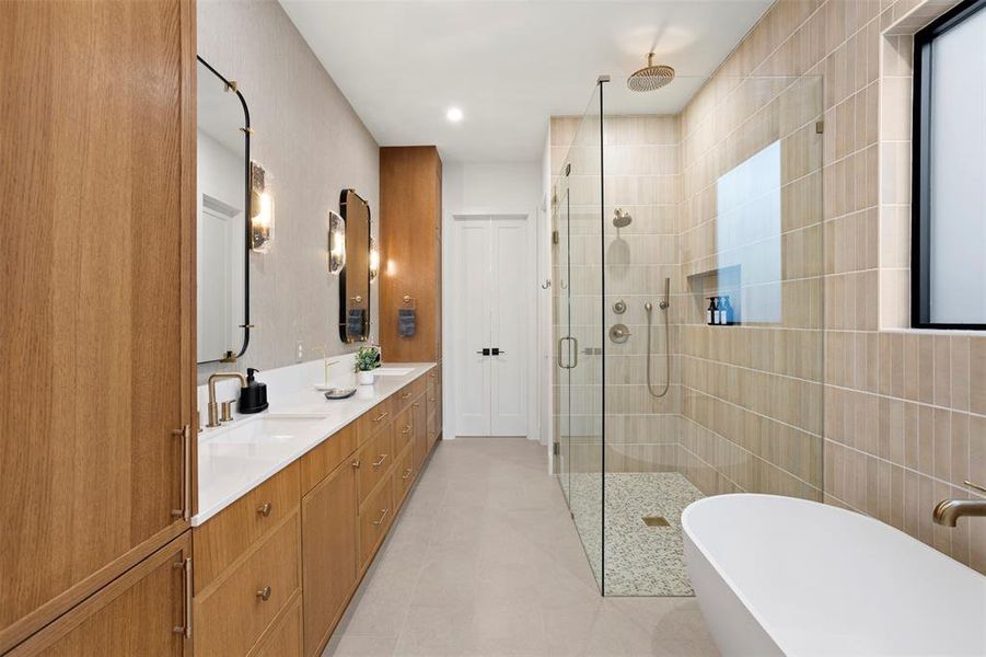 Spacious bathroom featuring a dual vanity with wood-finish cabinetry, quartz countertops, and modern brass fixtures