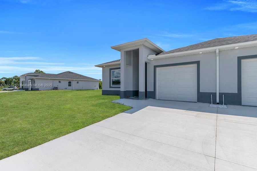 Front exterior of a new home in , Lehigh Acres, FL, highlighting curb appeal (Image 23).