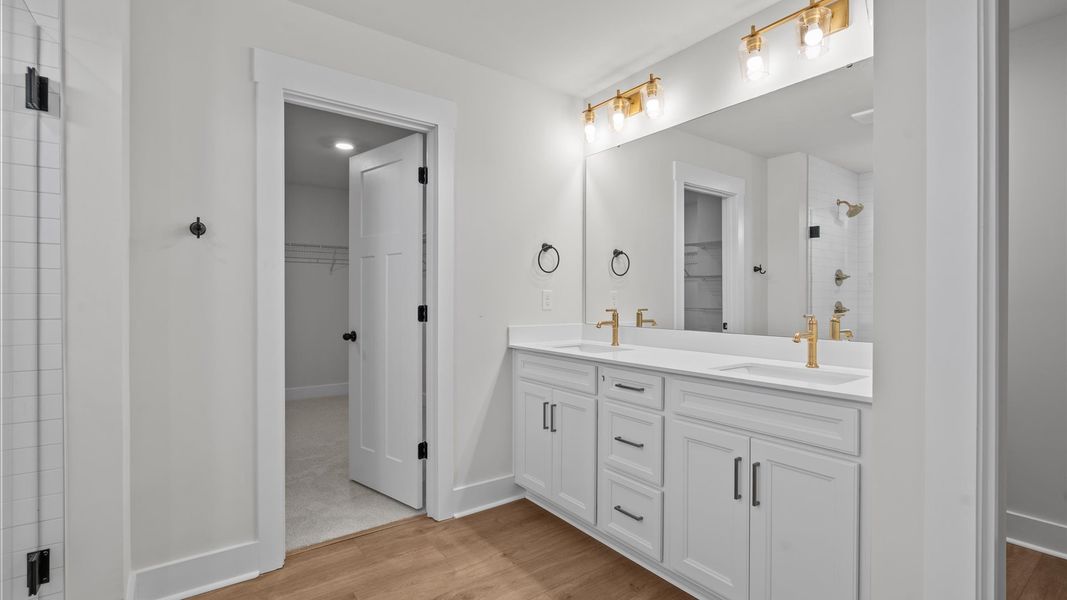 Notable primary suite with dual vanities and tiled walk-in shower in this prime home Notable primary suite with dual vanities and tiled walk-in shower in this prime home