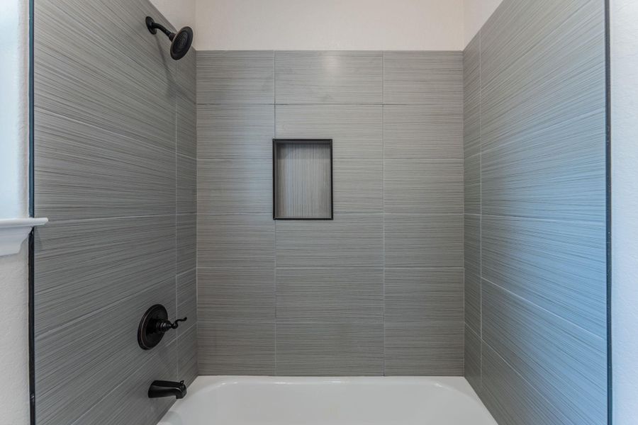Tub and shower combination featuring horizontal-patterned grey tile surround