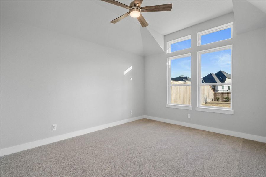 Retreat to this bright and airy primary bedroom, a serene sanctuary designed for ultimate relaxation and comfort. Vaulted ceilings, large windows, tile plank flooring, and modern ceiling fan give this room a peaceful space to come home to.