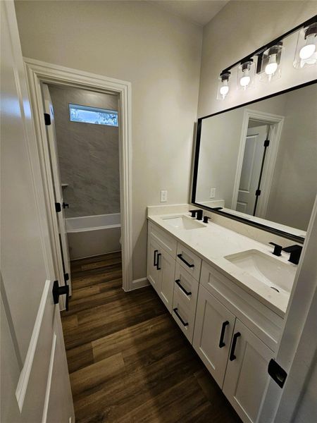 Bathroom with double vanity and dark wood finished floors