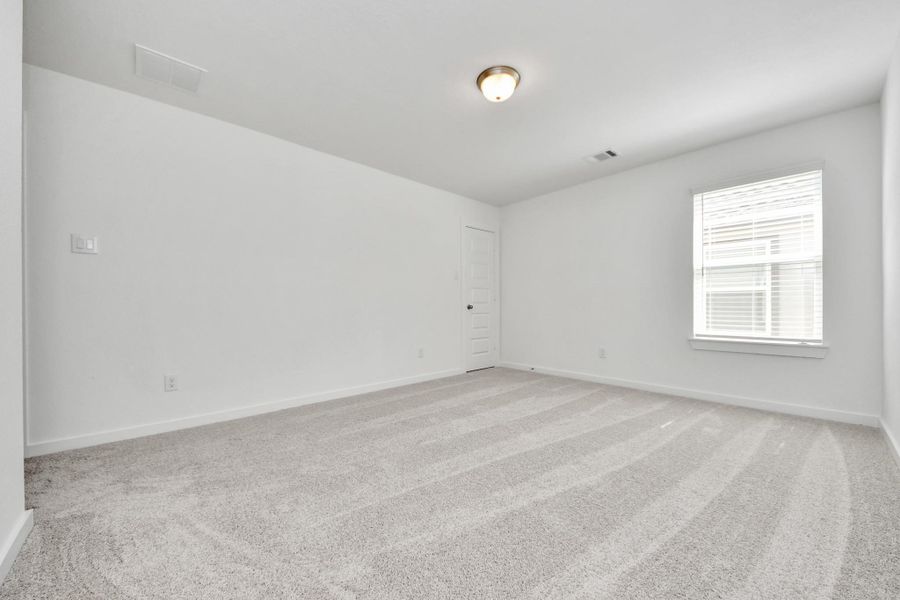 Secondary bedroom features plush carpeting, large windows that let in plenty of natural light, bright paint, and spacious closets.