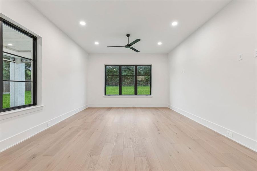 Spare room featuring recessed lighting, healthy amount of natural light, light wood finished floors, and a ceiling fan