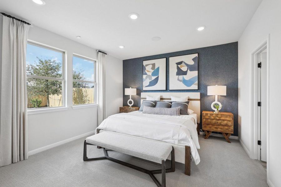 Two large windows illuminate this bedroom, featuring plush carpeting and recessed lighting. Two large windows illuminate this bedroom, featuring plush carpeting and recessed lighting.