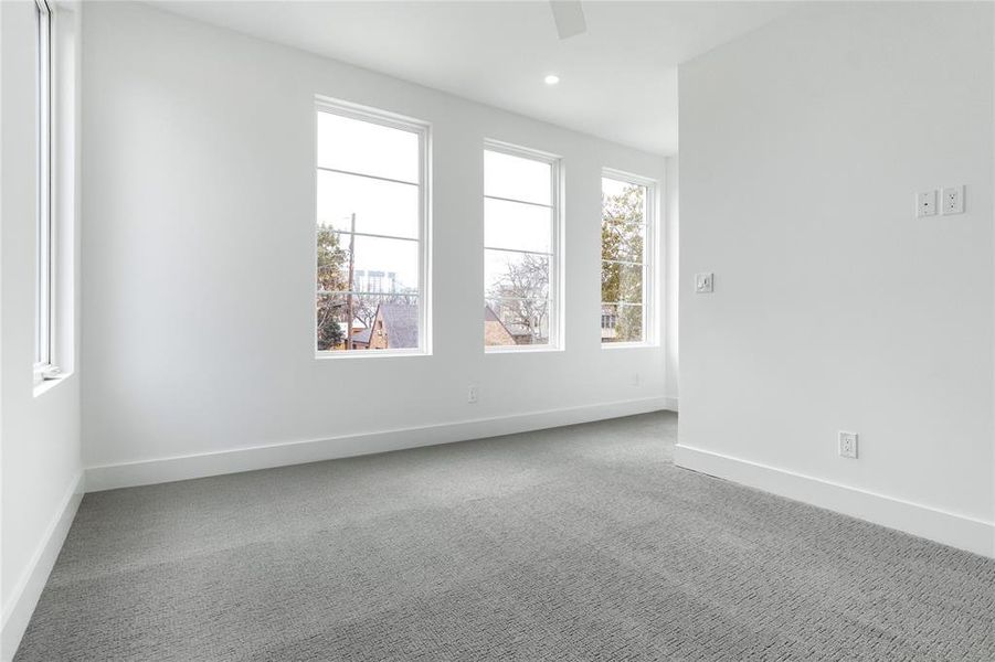 Carpeted spare room featuring ceiling fan