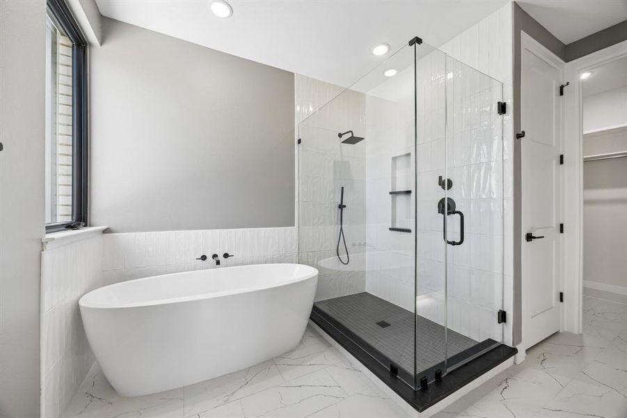 Full bathroom featuring a soaking tub, a stall shower, recessed lighting, light marble finish floors, and a wainscoted wall Full bathroom featuring a soaking tub, a stall shower, recessed lighting, light marble finish floors, and a wainscoted wall