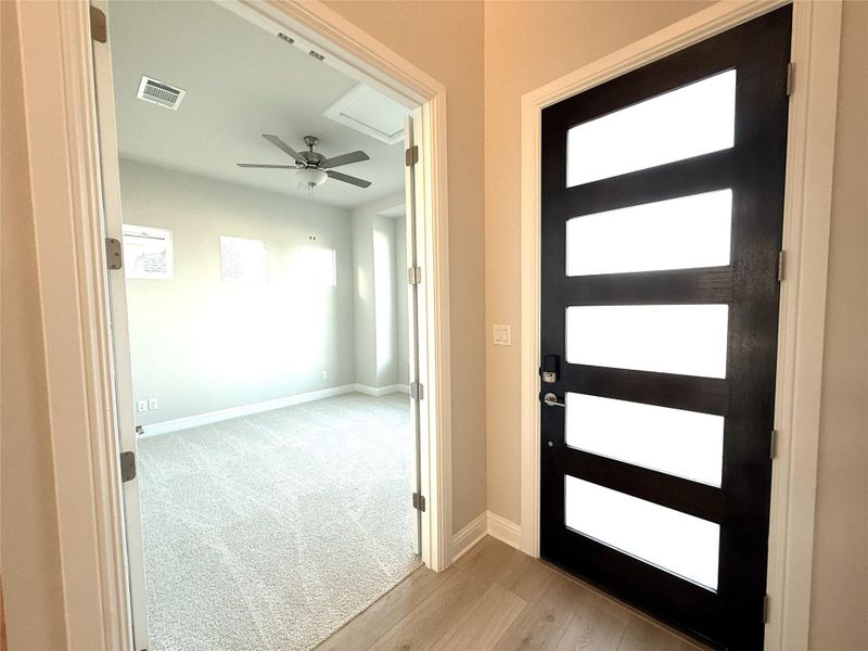 Entryway featuring healthy amount of natural light, a ceiling fan, and light colored carpet