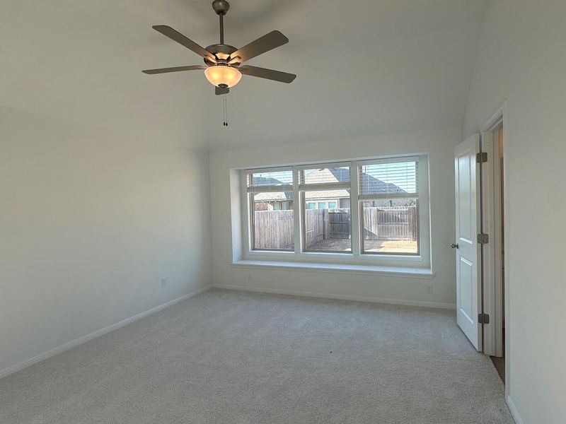Carpeted empty room featuring baseboards and ceiling fan Carpeted empty room featuring baseboards and ceiling fan