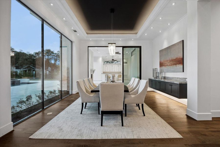 Large dining room with built-in storage has views of the pool area and access to the outdoor living room with summer kitchen.