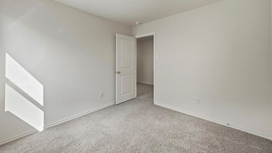 Empty room featuring carpet flooring and baseboards