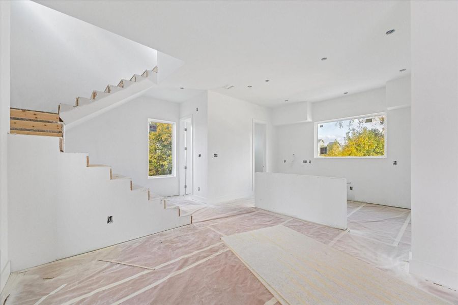 View from the dining room looking at the kitchen as of December 12, 2025. The door next to the vertical window is the powder bath and the door at the back of the kitchen leads to the pantry.