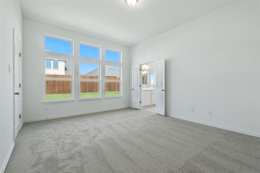 Empty room featuring light colored carpet and baseboards