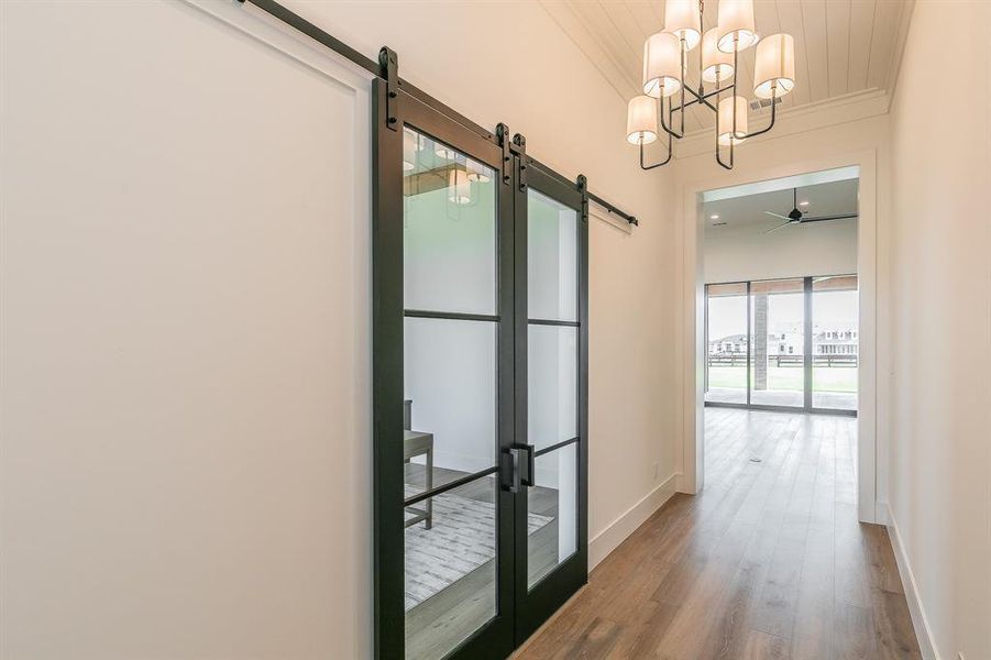 Inviting entry with chandelier and barn doors to the office.
