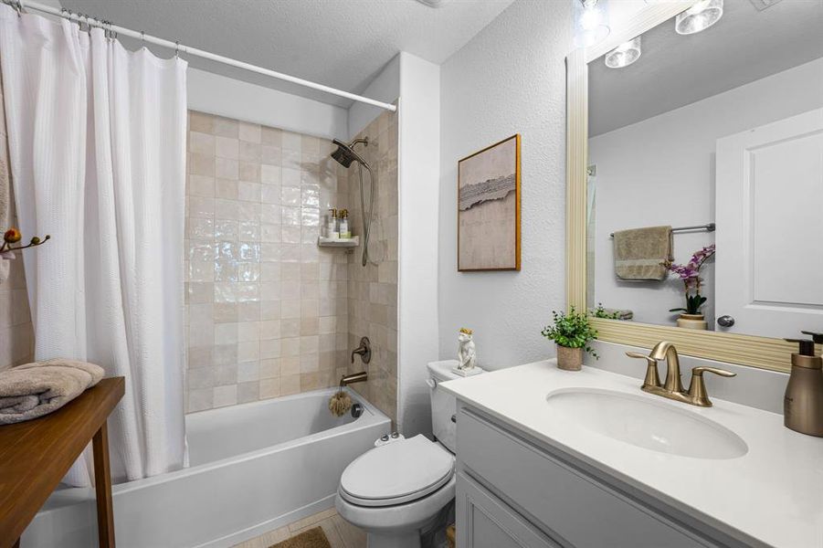 Bathroom featuring a a vanity and tub - shower combination. Bathroom featuring a a vanity and tub - shower combination.