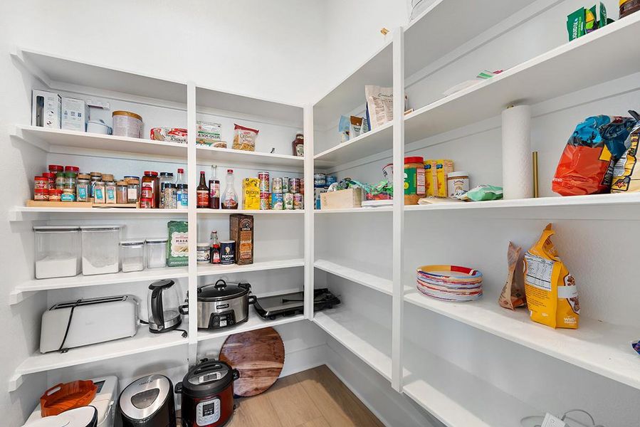 Ample built-in shelving provides exceptional storage space inside this walk-in pantry.
