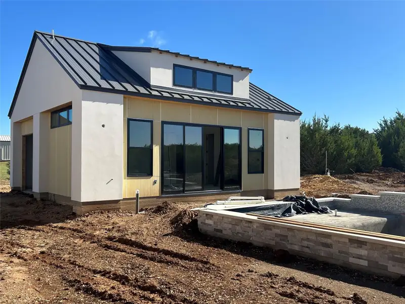 Rear view of property with a patio area, a metal roof, and a standing seam roof Rear view of property with a patio area, a metal roof, and a standing seam roof