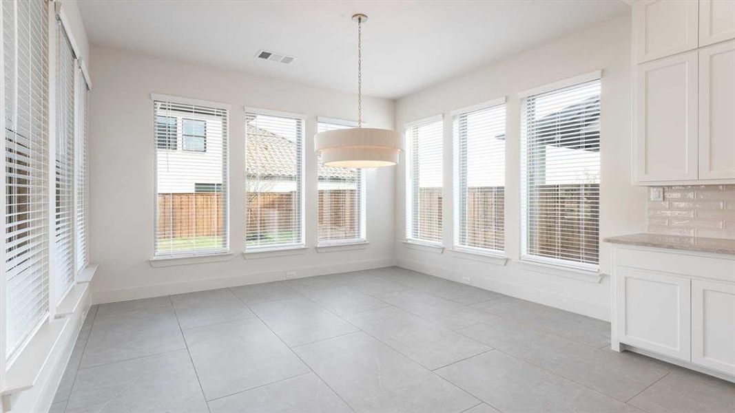 Unfurnished dining area with light tile patterned floors and a healthy amount of sunlight