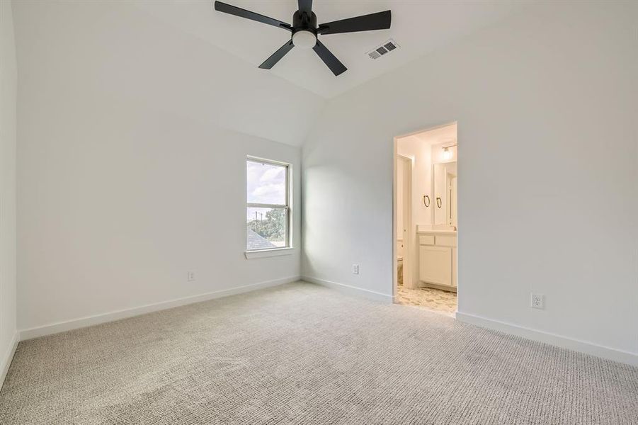 Carpeted spare room with vaulted ceiling and ceiling fan