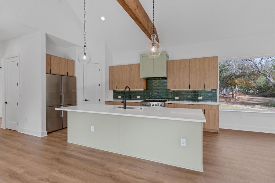 An open-concept kitchen with vaulted ceilings, a large island, and contemporary wooden cabinetry, perfect for entertaining. An open-concept kitchen with vaulted ceilings, a large island, and contemporary wooden cabinetry, perfect for entertaining.