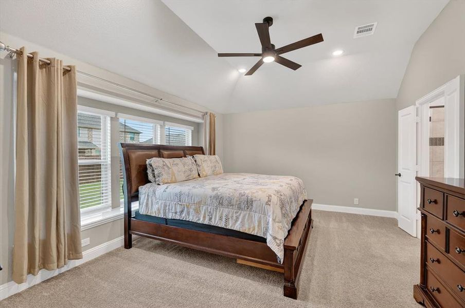 Vaulted ceiling room featuring light-toned carpet, recessed lighting, and a dark-toned ceiling fan Vaulted ceiling room featuring light-toned carpet, recessed lighting, and a dark-toned ceiling fan