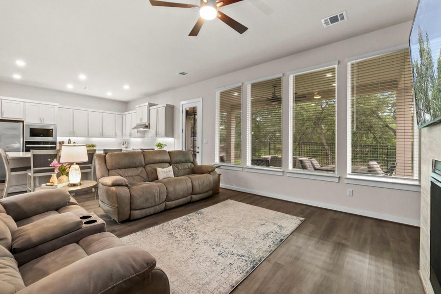 Open-concept living area featuring wood-finish flooring, a contemporary ceiling fan, and recessed lighting