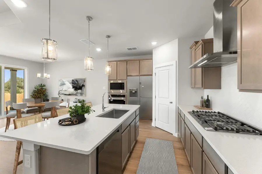 Culinary delights await in this modern kitchen, featuring an expansive island with sink and stainless appliances. Culinary delights await in this modern kitchen, featuring an expansive island with sink and stainless appliances.