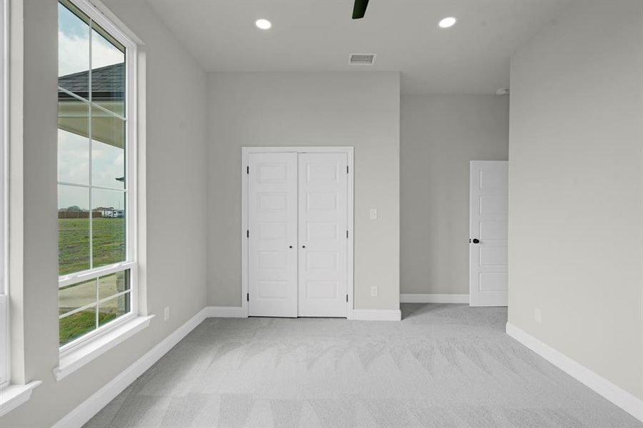 Unfurnished bedroom featuring a closet, ceiling fan, and light colored carpet