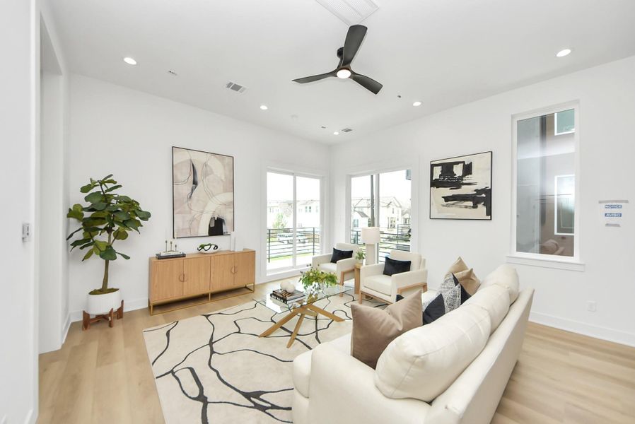 Inviting living area filled with natural light and complemented by contemporary finishes and light wood flooring.