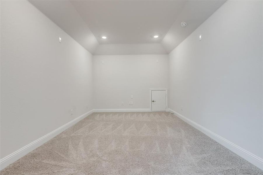 Empty room featuring recessed lighting, vaulted ceiling, light carpet, a smoke detector, and baseboards