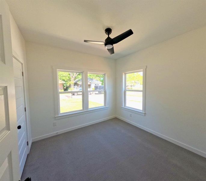 Spare room with dark colored carpet and a ceiling fan Spare room with dark colored carpet and a ceiling fan