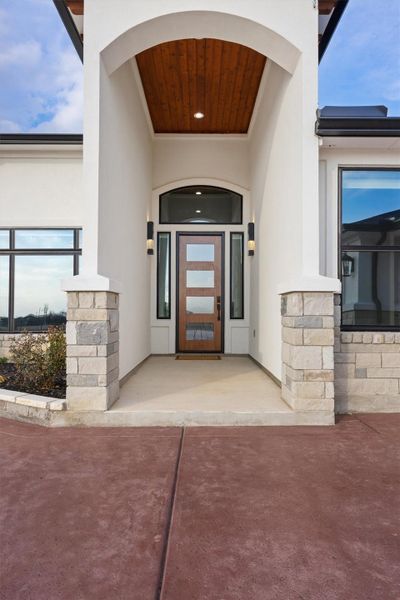 View of exterior entry featuring stucco siding and stone siding