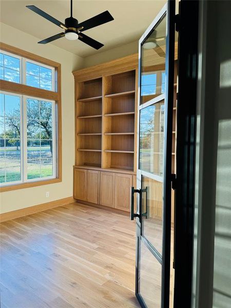 Empty room with light hardwood / wood-style flooring and ceiling fan