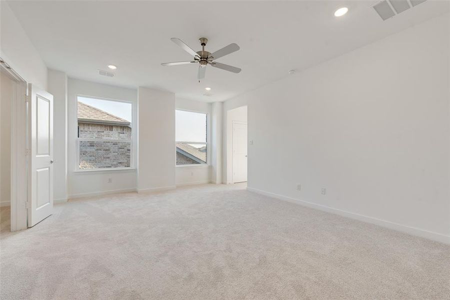 Unfurnished room with light colored carpet and ceiling fan