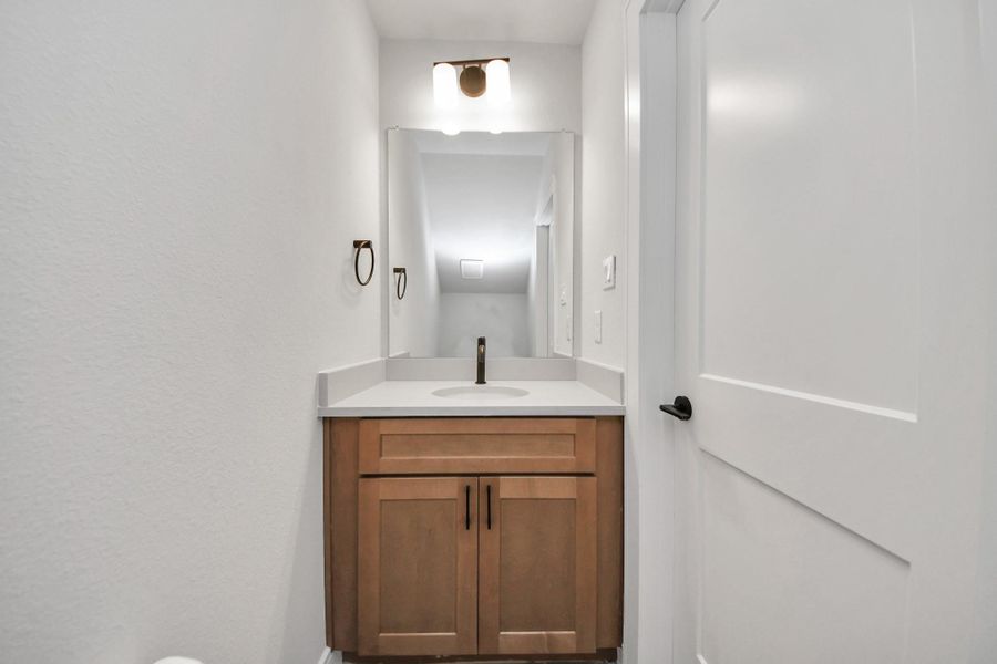 1st Floor half bath with modern hardware, upgraded cabinets, and light counter tops.