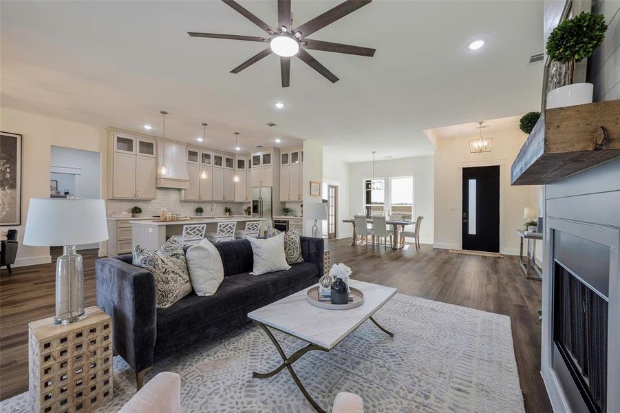 Spectacular open-concept living showcasing the seamless connection between living room, kitchen, and dining areas. Soaring ceilings and abundant natural light create an airy, welcoming atmosphere. Modern farmhouse finishes include rich hardwood floors, shiplap accents, and designer lighting throughout this stunning great room.