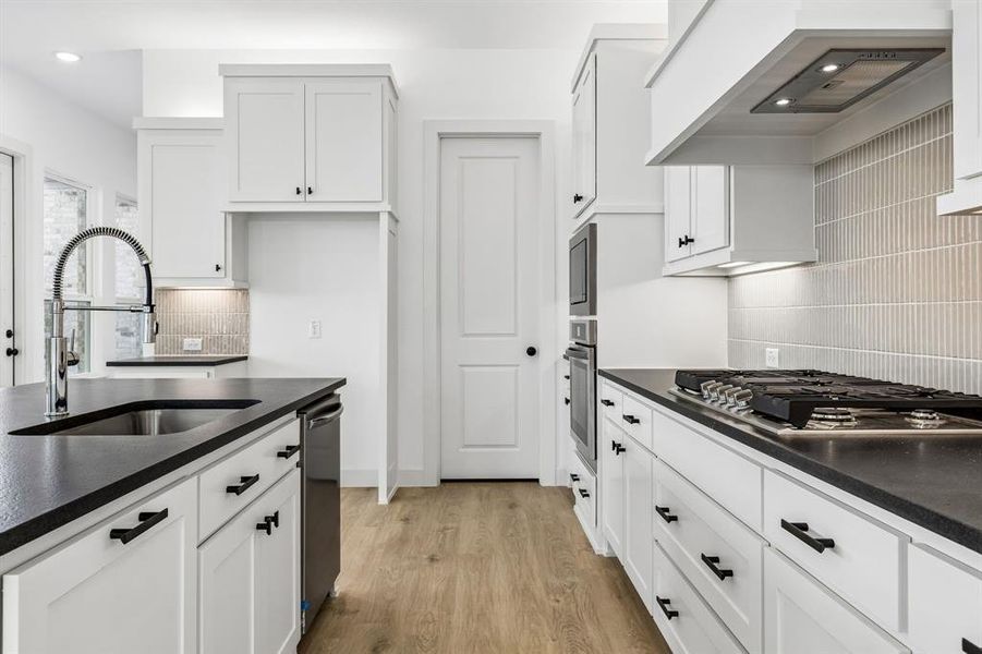 Beautiful cabinetry, striking counter tops and a modern backsplash effortlessly blend with contemporary stainless steel to create a kitchen for the ages!