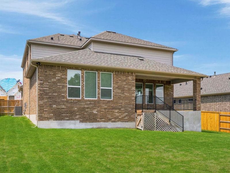 A neatly maintained lawn extends from the brick-clad rear of this residence, featuring a covered patio with direct access. A neatly maintained lawn extends from the brick-clad rear of this residence, featuring a covered patio with direct access.