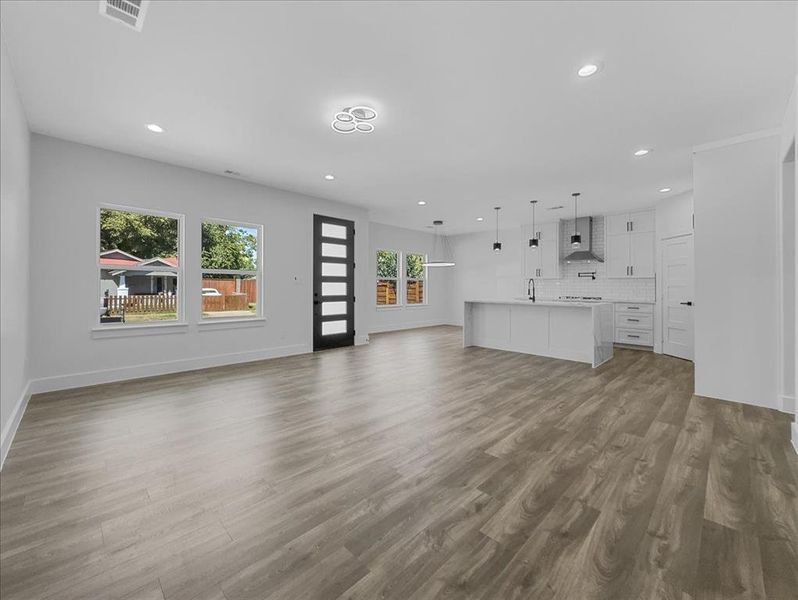 Unfurnished living room featuring recessed lighting and dark wood-style flooring Unfurnished living room featuring recessed lighting and dark wood-style flooring