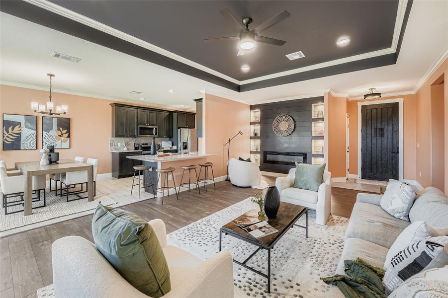 Living area with ornamental molding, a chandelier, ceiling fan, light wood-style floors, and recessed lighting