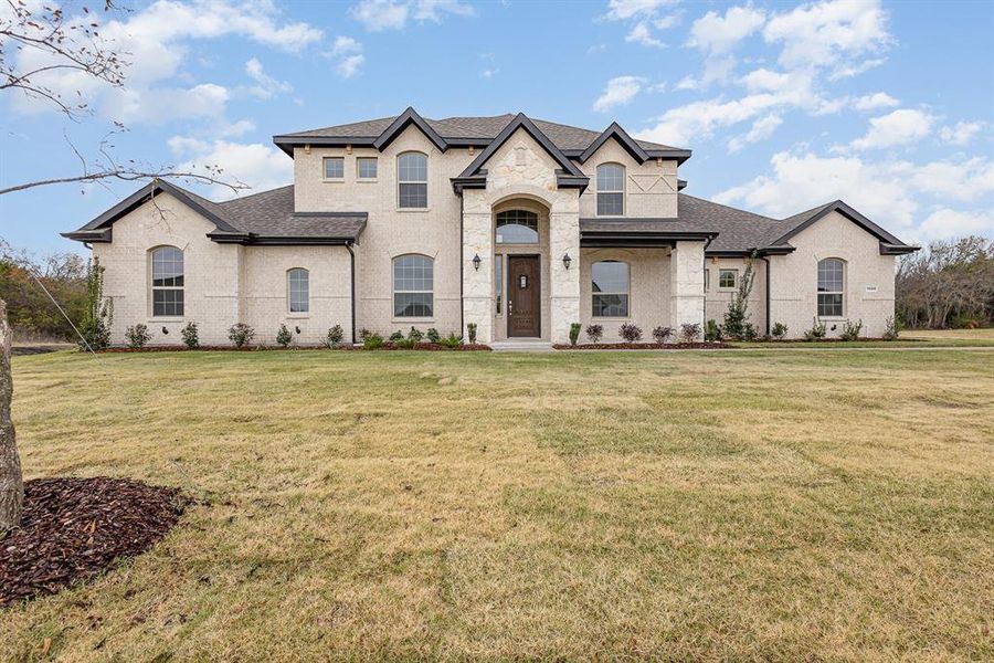 French country style house featuring a front lawn