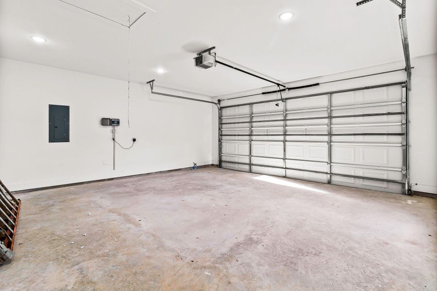 This is a spacious, clean two-car garage with a concrete floor and modern overhead door. It features ample lighting and electrical outlets, ideal for storage or workshop use. This is a spacious, clean two-car garage with a concrete floor and modern overhead door. It features ample lighting and electrical outlets, ideal for storage or workshop use.