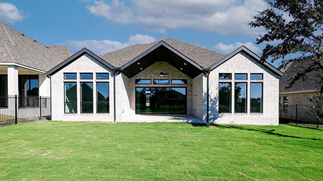 Back of house with ceiling fan, a patio, and brick siding Back of house with ceiling fan, a patio, and brick siding