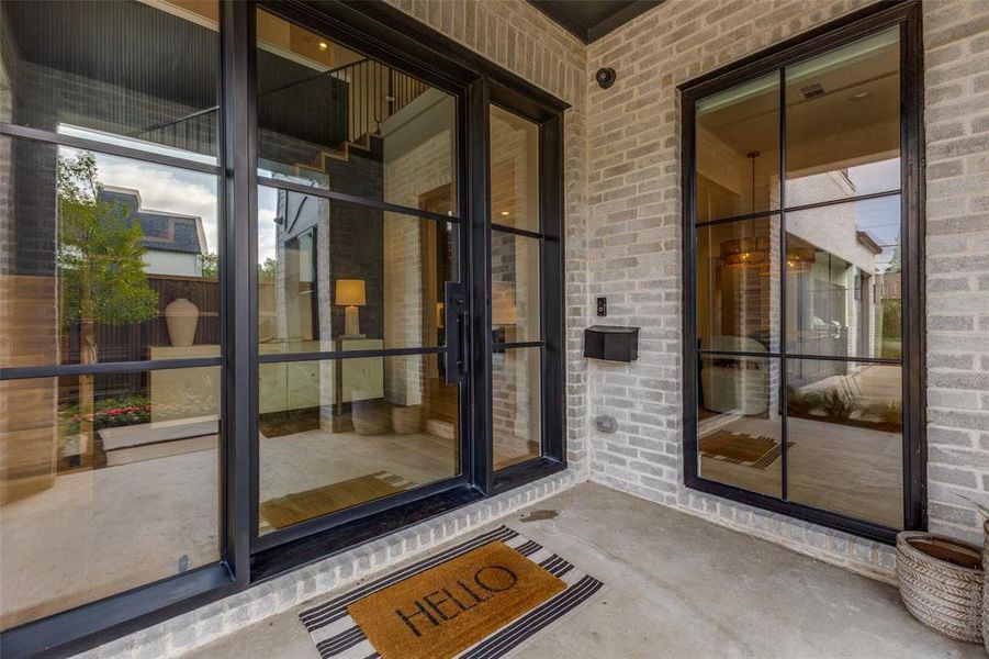 Modern brick exterior featuring black-framed windows and a double-door entry Modern brick exterior featuring black-framed windows and a double-door entry