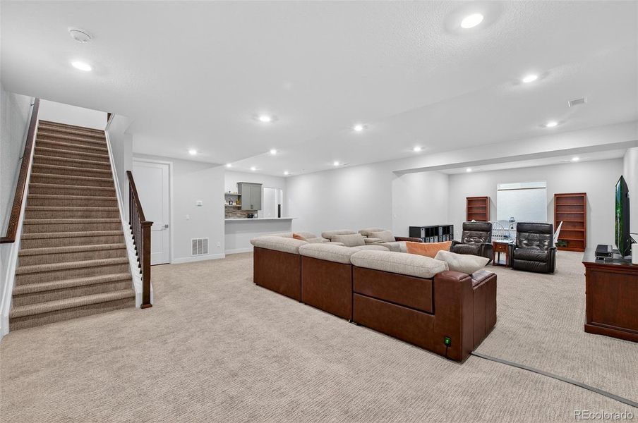 Basement Family Room (Wide View) – Expansive finished basement offering a spacious family or media room with recessed lighting, plush carpeting, and neutral finishes ideal for relaxation or entertaining.