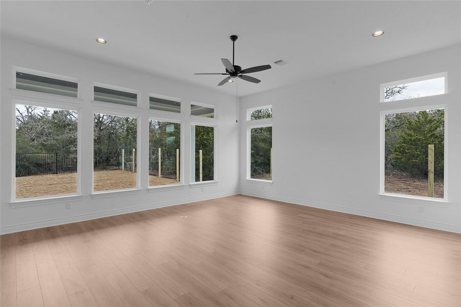 Unfurnished room featuring wood finished floors, a ceiling fan, recessed lighting, and plenty of natural light