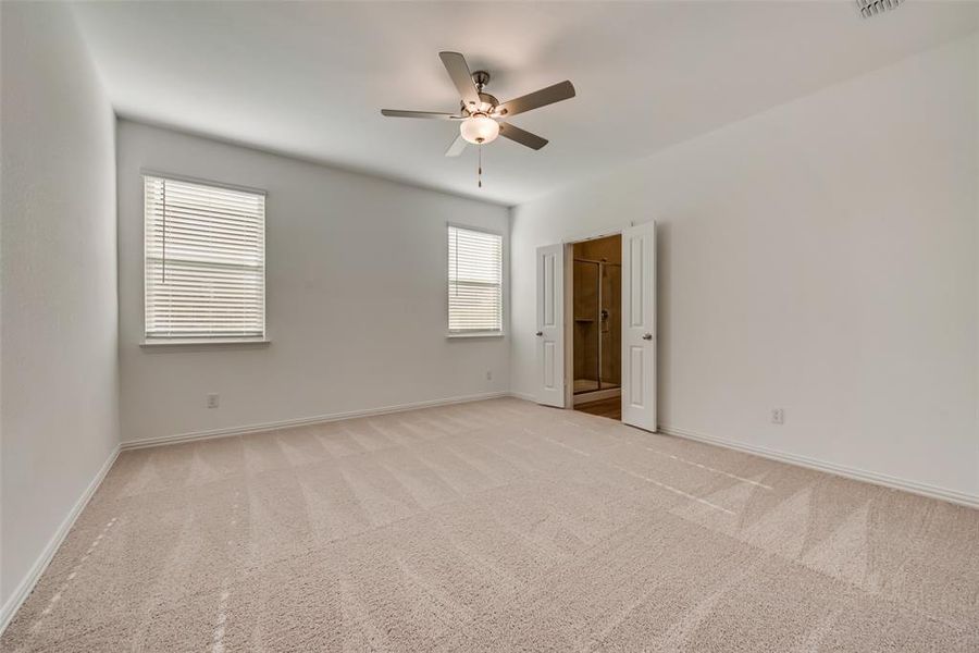 Carpeted empty room featuring ceiling fan