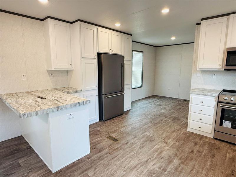 Kitchen with stainless steel appliances, white cabinets, and a peninsula