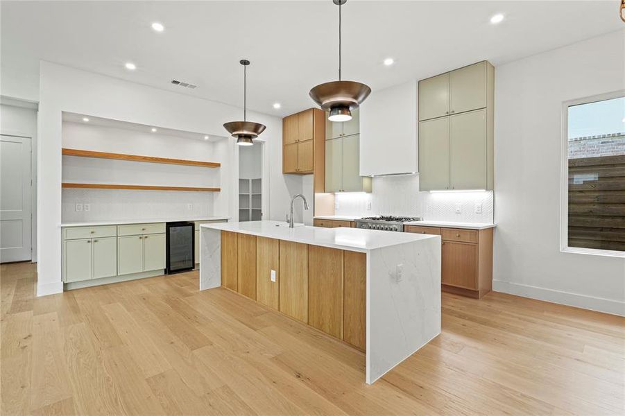 Kitchen with open shelves, light stone countertops, light wood finished floors, modern cabinets, and recessed lighting