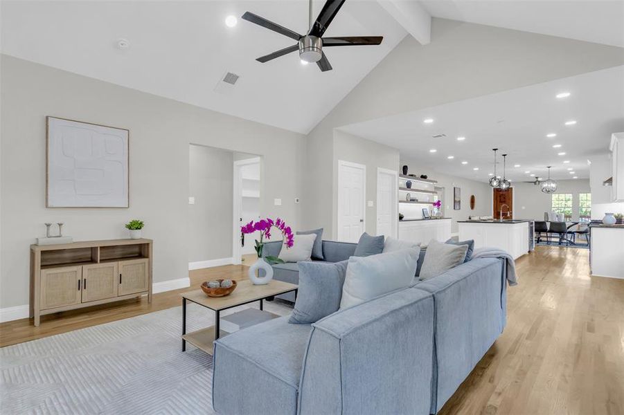 Living room with beamed ceiling, light wood-type flooring, recessed lighting, high vaulted ceiling, and a ceiling fan